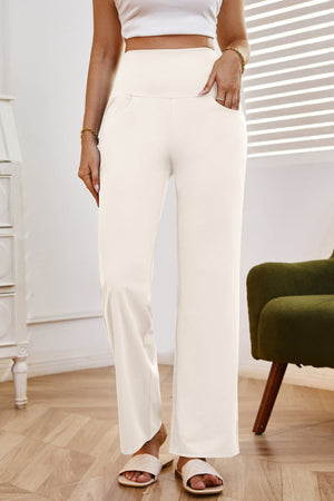 High-waisted flare leg trousers in white with pockets, styled casually.