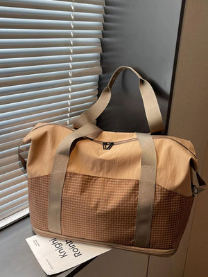 Spacious nylon travel duffel bag in tan with a checkered lower panel and tan straps.