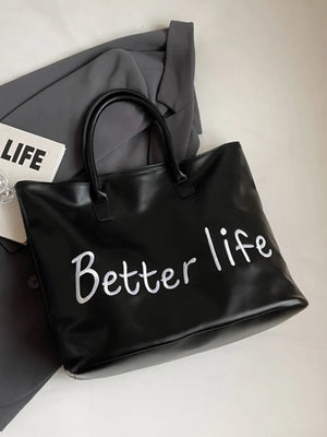 Black tote bag with white metallic "Better Life" graphic and double handles.