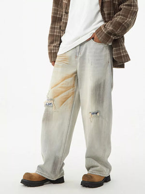 Distressed light wash wide-leg jeans with unique patches and a relaxed fit.