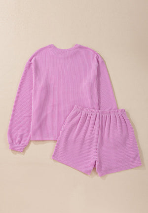 Pink textured loungewear set with a long sleeve top and shorts.