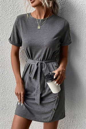 Dark gray tee dress with short sleeves, tie waist, and button detail on skirt.