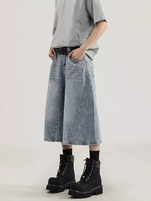 Men's light wash denim capris with a relaxed fit and wide leg, styled with a grey t-shirt and black boots.