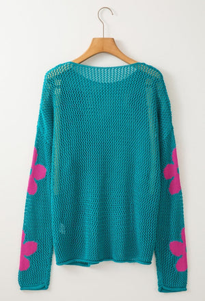 Teal openwork sweater with pink floral intarsia on sleeves.
