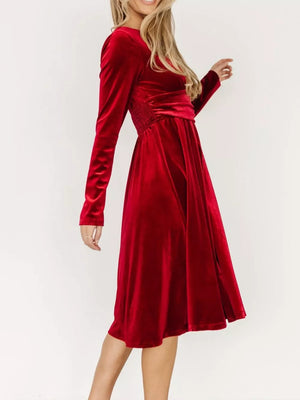 Red velvet midi dress with long sleeves, V-neck, and ruched waist detail.