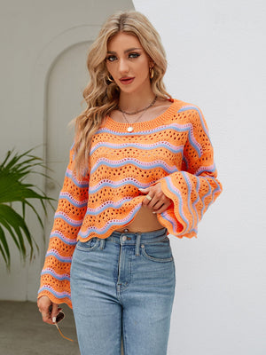 Crochet crop sweater in orange-red with blue stripes, featuring scalloped hem and bell sleeves.