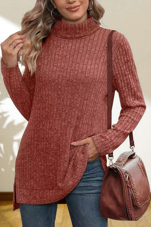 Ribbed knit turtleneck tunic top in red orange with side slits and a relaxed fit.