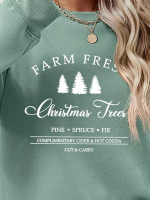 Sage green sweatshirt with "Farm Fresh Christmas Trees" graphic and holiday text.
