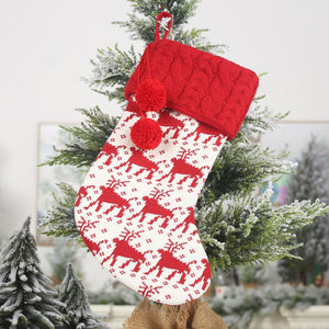 Red and white cable knit Christmas stocking with reindeer pattern and pom poms