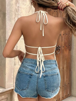 Apricot cami top with halter neck and tie back, paired with denim shorts