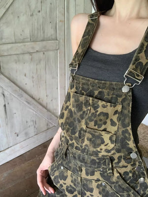 Chic leopard print denim overall dress with adjustable straps and buckle detail.
