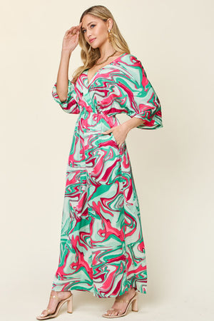 Green swirl print kimono sleeve jumpsuit with a V-neck and wide legs.