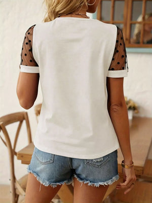 White t-shirt with black polka dot sheer mesh sleeves and crew neck.