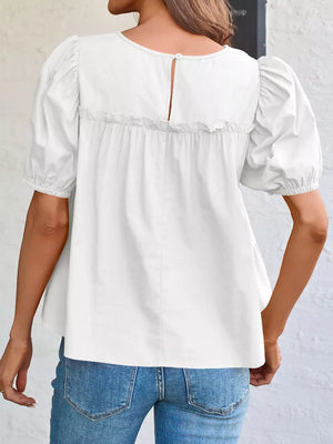 White maternity blouse with puff sleeves, ruffled yoke, and button back detail.