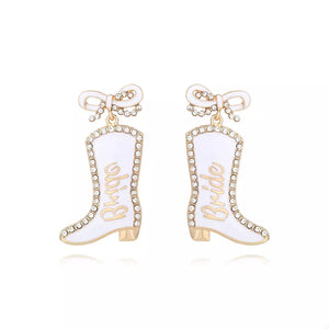 White bridal cowboy boot dangle earrings with gold trim and rhinestones.