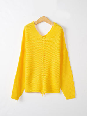 Yellow knit sweater with V-neck, lace-up detail and drawstring hem