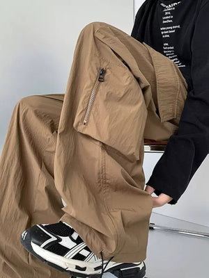 Men's camel cargo sweatpants with zippered pocket detail and drawstring.