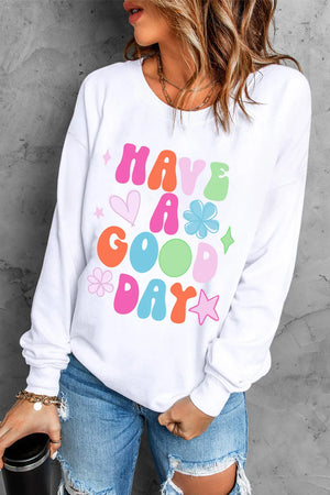White crewneck sweatshirt with colorful "Have A Good Day" graphic and playful icons.