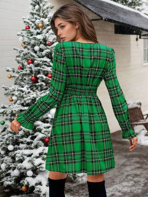 Green plaid mini dress with smocked waist and ruffled cuffs.