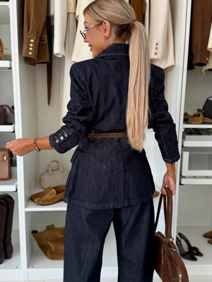 Dark blue denim double-breasted pant suit with a belted waist and buttoned cuffs.