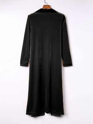 Black velvet duster coat with fluid silhouette, long sleeves and notched collar.
