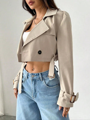 Beige cropped double-breasted trench coat with belted waist and adjustable cuffs.