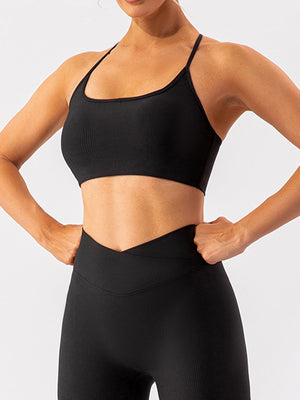 Black ribbed halterneck active bra with thin straps and a cropped fit.