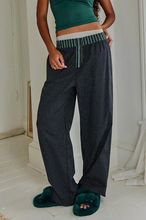 Black polka dot lounge trousers with a striped waistband and drawstring detail.