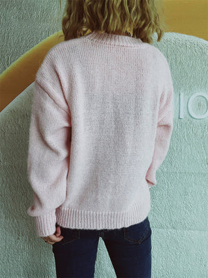 Blush pink knit crewneck sweater with embellished bow detail.