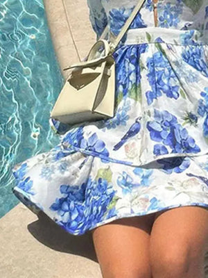 Blooming ruffle mini dress in sky blue floral print with tiered skirt and bird detail.