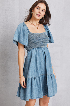 Light denim puff sleeve prairie dress with smocked bodice and tiered skirt.