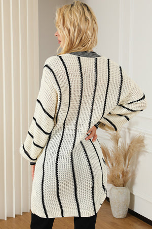 Ivory knit oversized V-neck dress with black vertical stripes and waffle texture.