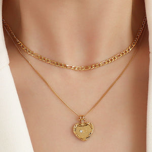 Gold layered necklace with figaro chain and heart locket pendant with diamond accent