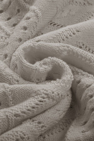 Gray openwork knit sweater with intricate stitch details and a soft texture.