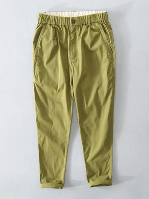 Men's green elastic waist cargo pants with cuffed hem and button detail.