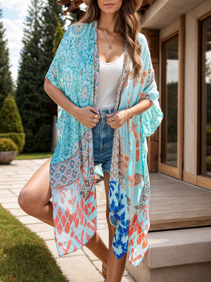Bohemian patchwork print kimono in light blue with short sleeves and an open front, styled with denim shorts.