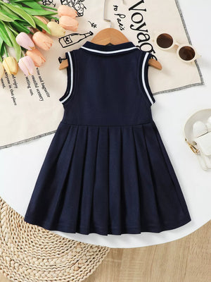 Navy sleeveless baby dress with pleated skirt and white striped collar and armholes.