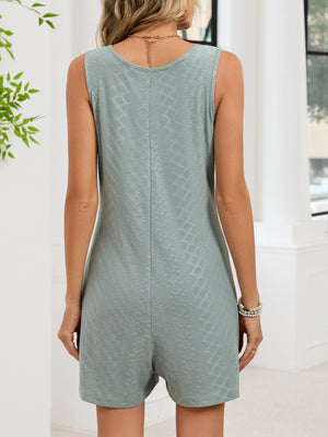 Sage sleeveless romper with textured pattern and button details.