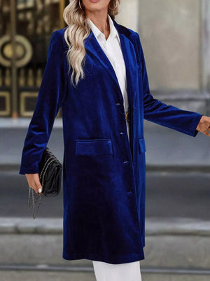 Longline velvet trench coat in dark blue with lapel collar and buttoned front.