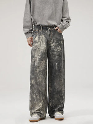 Dark gray wide-leg jeans with distressed paint splatter detail and a relaxed fit.