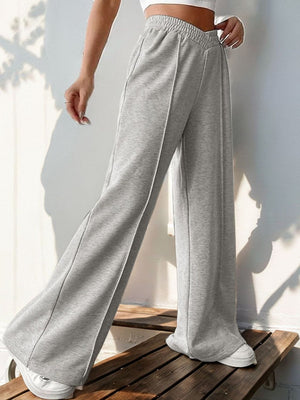 Light gray V-waistline pleated palazzo trousers with a relaxed fit and wide leg.