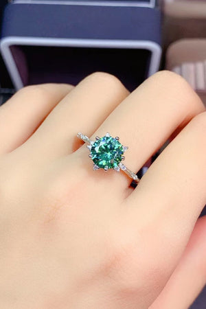 Emerald cut moissanite platinum ring with celestial halo in green.