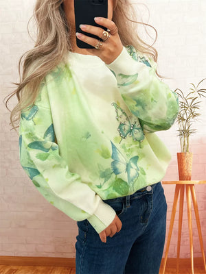 Lightweight knit sweater with allover butterfly print and rhinestone details in green and white.
