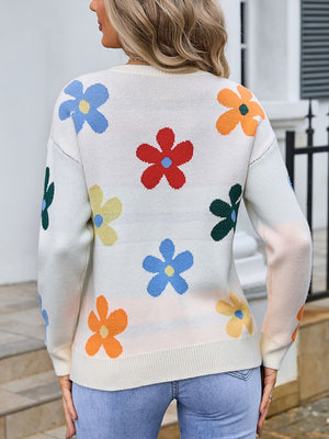 White knit crewneck sweater with colorful floral pattern and long sleeves.