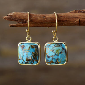 Turquoise matrix square drop earrings with gold-tone hooks.
