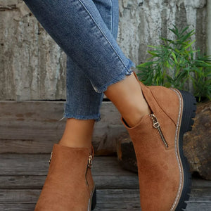 Brown suede ankle boots with side zipper and rugged sole.