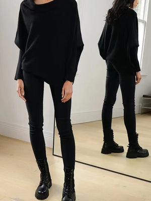 Black off-shoulder drape knit sweater with textured cuffs and batwing sleeves.