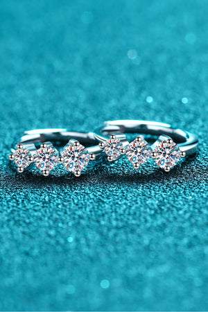 Silver huggie earrings with a triple stone cluster design, featuring sparkling clear gems.