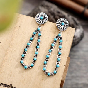 Silver floral turquoise bead drop earrings with a blossom pattern.