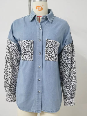 Denim shirt with leopard print sleeves and chest pockets. Button-up style.